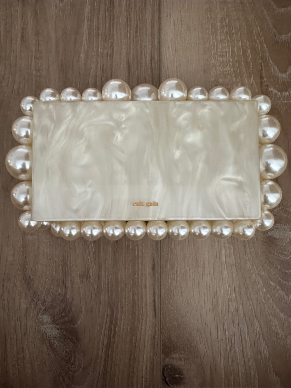 Cult Gaia pearl‑trim cream clutch